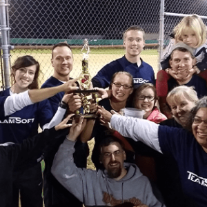 coworkers holding trophy after winning softball game
