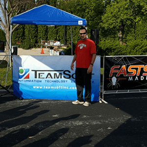 man standing in front of teamsoft booth at event