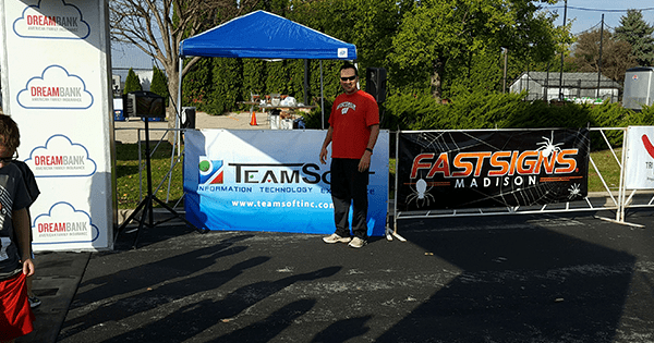 man standing in front of teamsoft booth at event