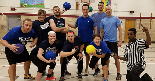 Coworkers posing for a picture before playing dodgeball together