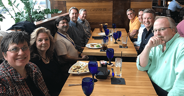 Coworkers sitting at a table together to celebrate 10 years