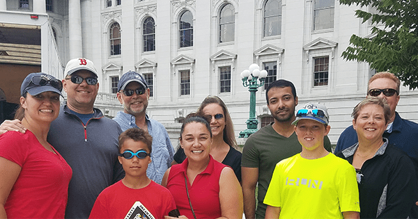 coworkers smiling together in front of a white building