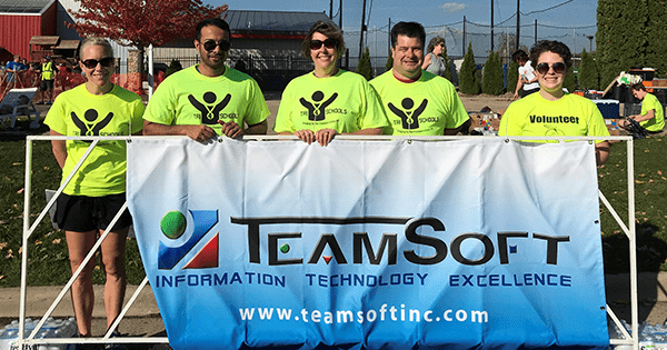 coworkers at Volunteer event holding a banner together