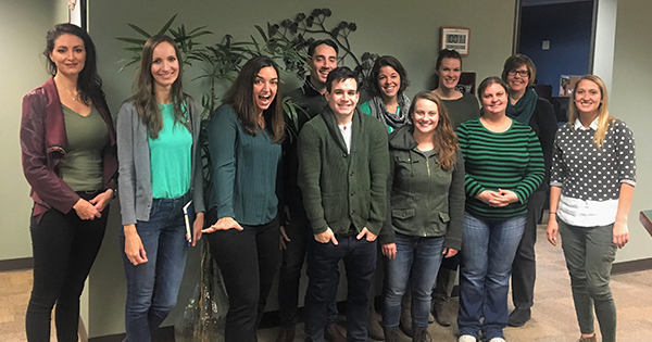 Coworkers standing together wearing green for the green light project