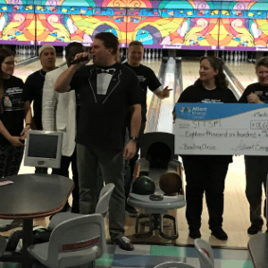 coworkers holding a check at a bowling event
