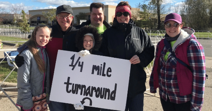 Cute child holding sign with adults