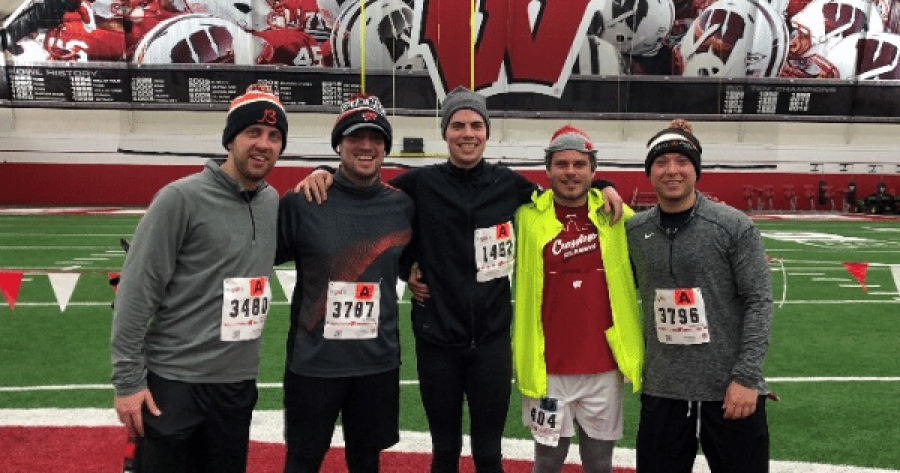coworkers stand together with arms around each other after running a race