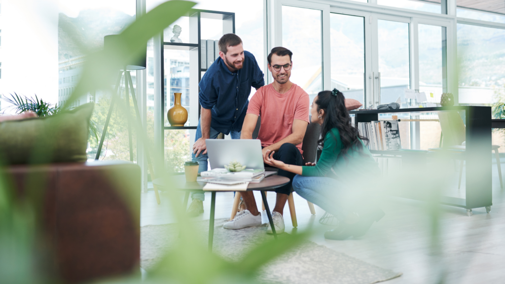 Three Tech Professionals Working in an Office Around a Computer