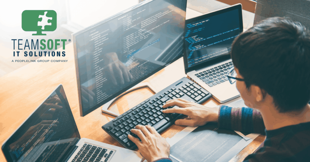 Coder at work typing on a keyboard in front of a monitor.
